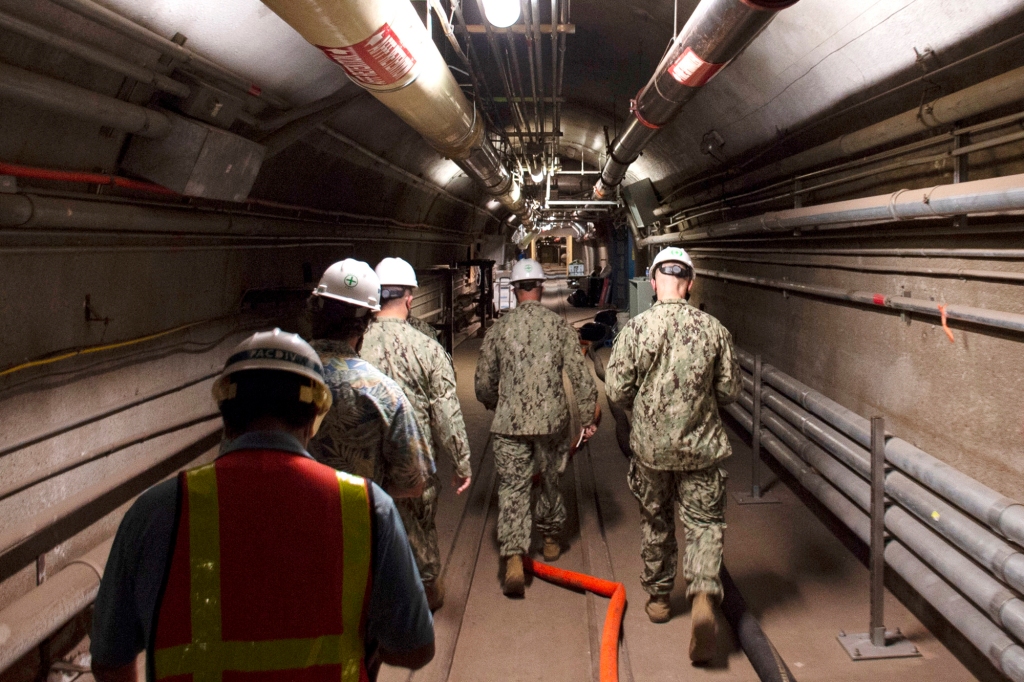 FILE - In this Dec. 23, 2021, photo provided by the U.S. Navy, Rear Adm. John Korka, Commander, Naval Facilities Engineering Systems Command (NAVFAC), and Chief of Civil Engineers, leads Navy and civilian water quality recovery experts through the tunnels of the Red Hill Bulk Fuel Storage Facility, near Pearl Harbor, Hawaii. The U.S. government on Friday, April 22, 2022 dropped its appeals of a Hawaii order requiring it to remove fuel from a massive military fuel storage facility that leaked petroleum into the Navy's water system at Pearl Harbor last year. 
