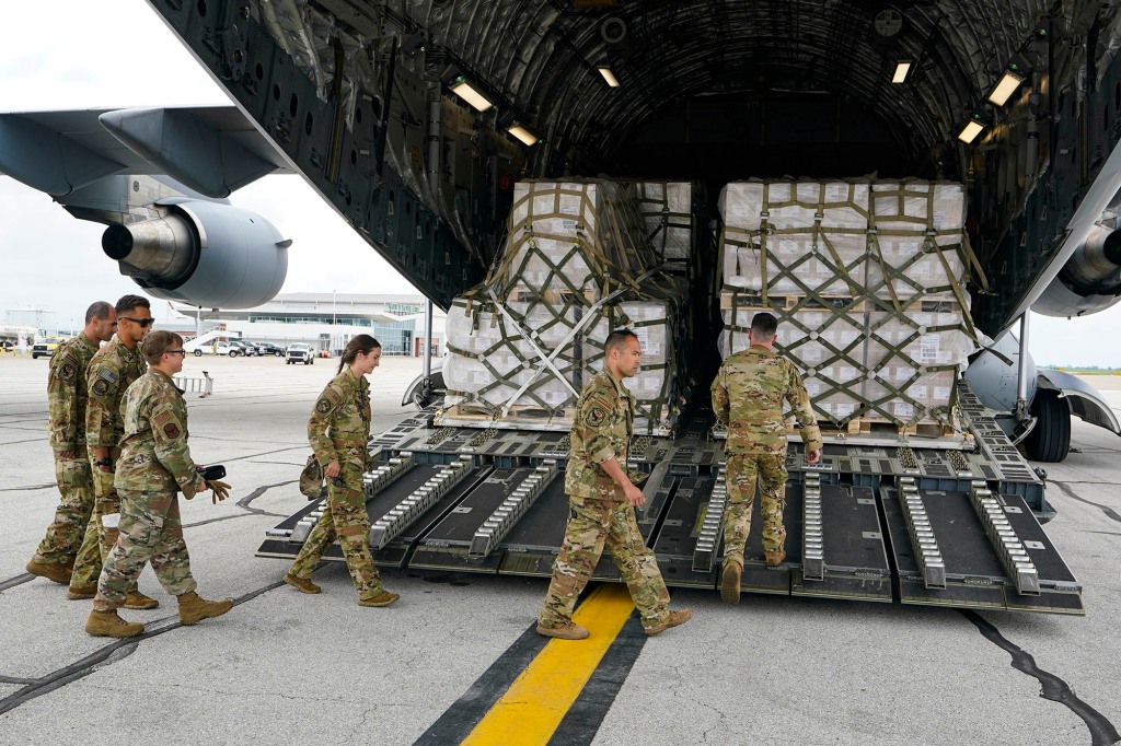 Crew members of a C-17 begins to unload a plane load of baby formula at the Indianapolis International Airport.