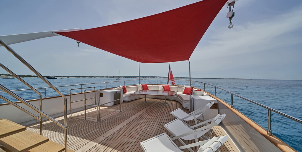 The main deck aft offers a shaded space for alfresco dining for all 12 guests around the large table, with sweeping views aft of the location.
