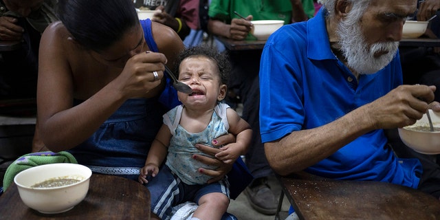 Zoraida Silva, 26, feeds her six month baby Jhon Angel, at a soup kitchen in The Cemetery slum, in Caracas, Venezuela. Silva said that she can not afford to have 3 meals a day, and she has been eating at the soup kitchen for two years ago. 