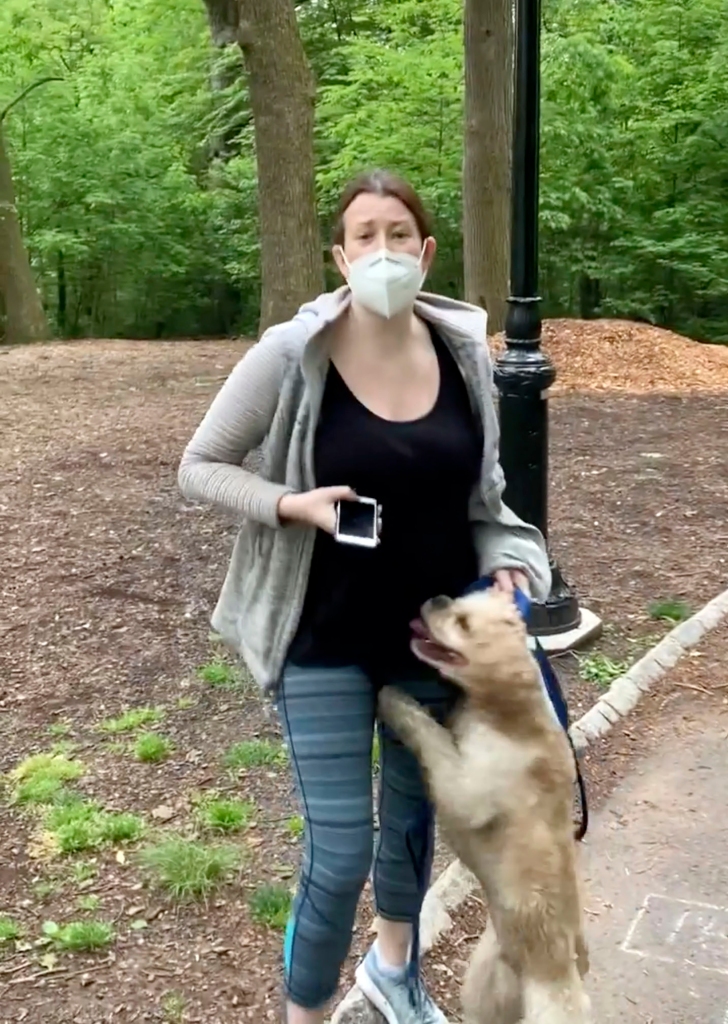 This image made from Monday, May 25, 2020, video provided by Christian Cooper shows Amy Cooper with her dog talking to Christian Cooper at Central Park in New York. Amy Cooper, the white woman who called 911 on Black birdwatcher Christian Cooper in New York's Central Park, is suing her former employer for firing her over the incident. (Christian Cooper via AP, File)