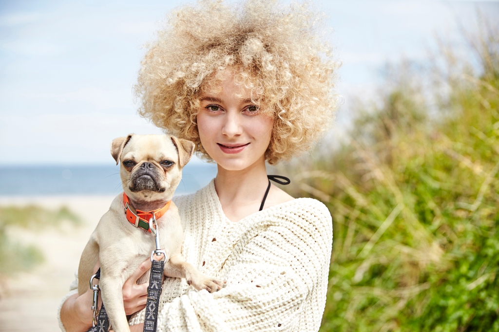 Woman holding dog on the beach