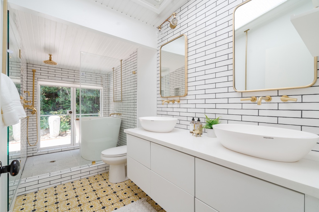 A rain shower stands next to a deep soaking tub in this bathroom.