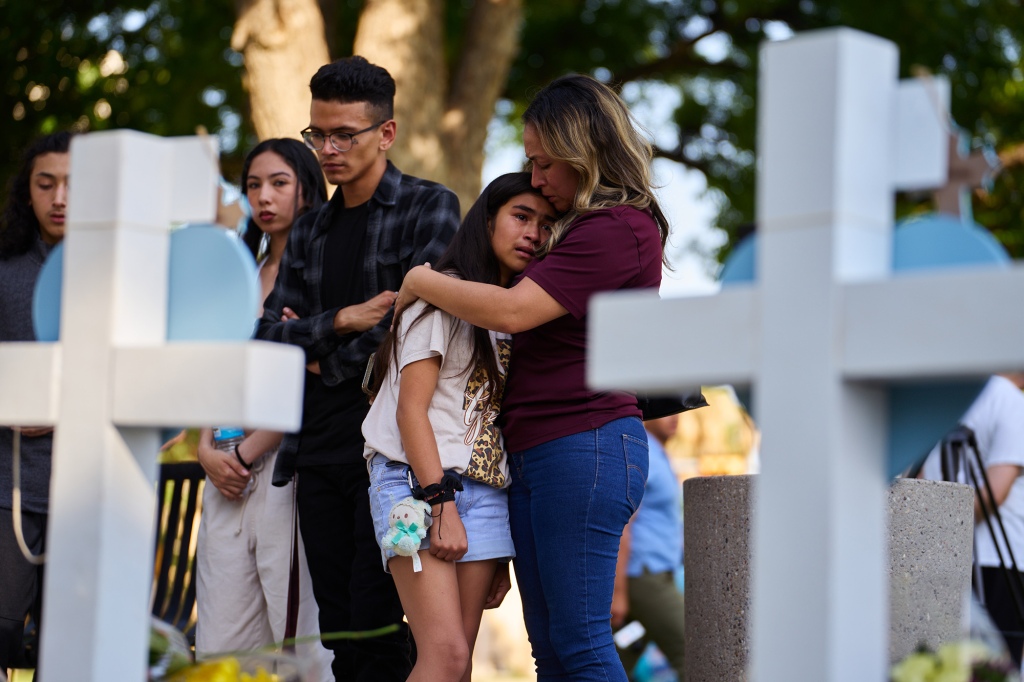 Mourners gather at a memorial at City of Uvalde Town Square.