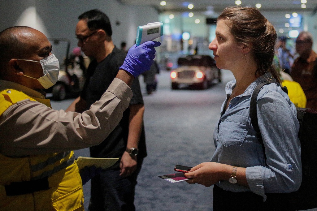 A health official screens passengers for Monkeypox at Soekarno-Hatta International Airport in Indonesia.