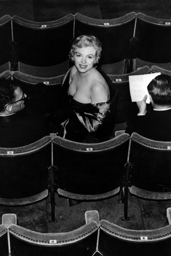 Marilyn Monroe takes her seat in the audience for a performance of the play "A View From The Bridge," written by her husband Arthur Miller (left).