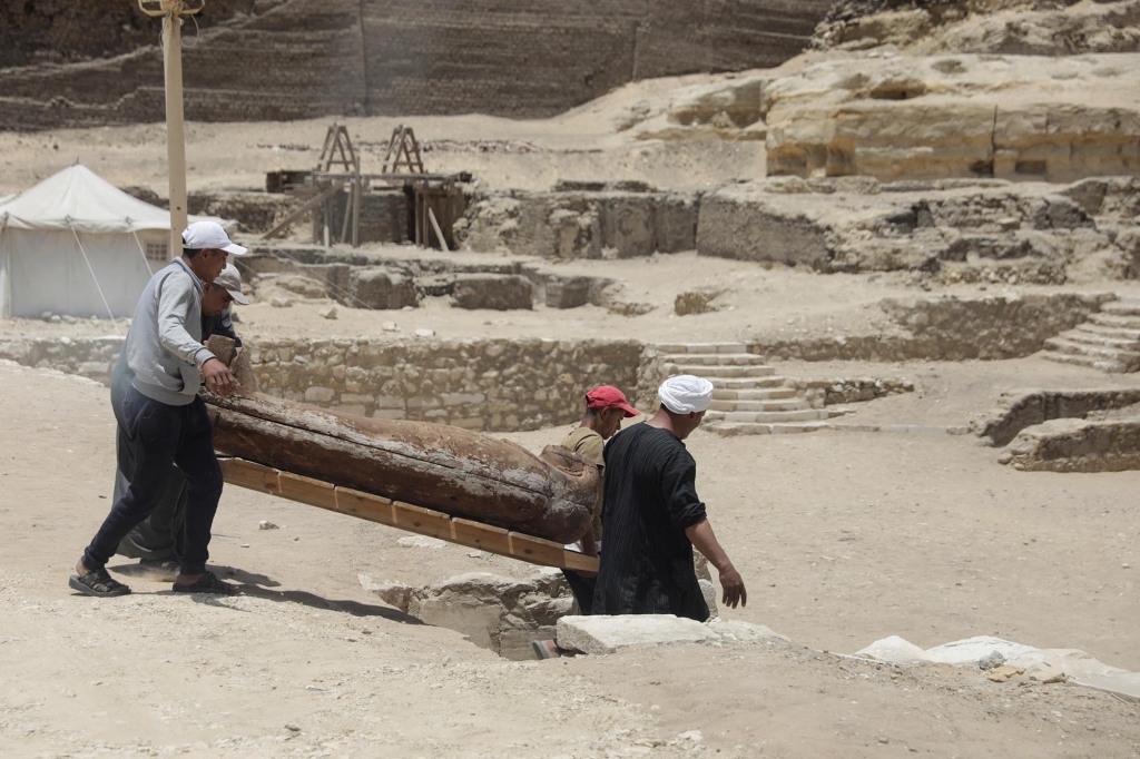Workers carry a sarcophagus.