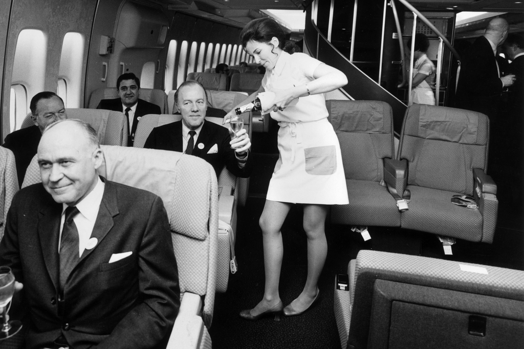 A Pan Amm airhostess serving champagne in the first class.