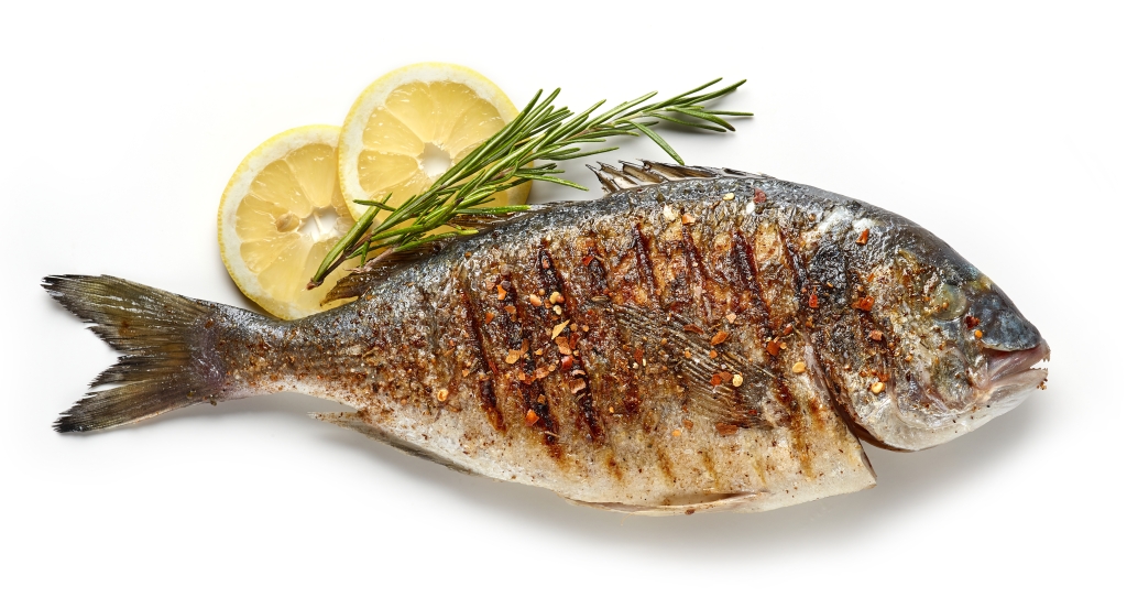 A cooked fish lies on a table.
