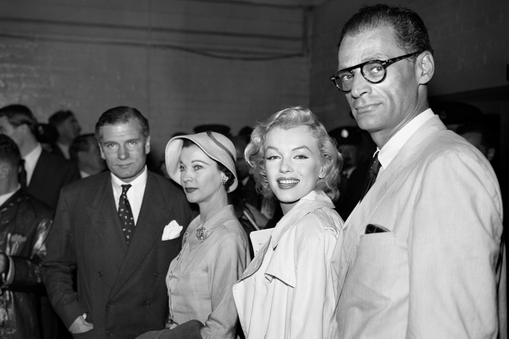 Sir Laurence and Lady Olivier at London Airport to meet Marilyn Monroe and her husband playwright Arthur Miller on their arrival from New York.