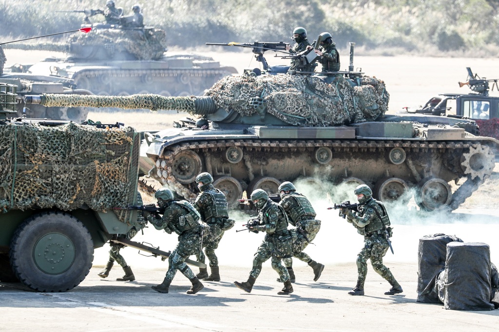Members of Taiwan's armed forces walks behind military vehicles during a military exercise in Hukou, Hsinchu County, Taiwan.