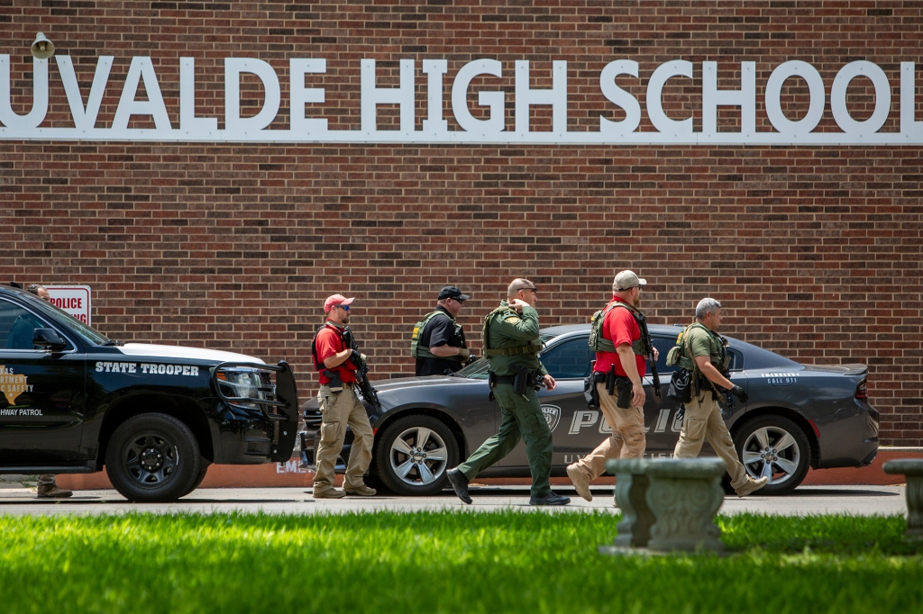 Law enforcement personnel walk outside Uvalde High School after shooting a was reported earlier in the day at Robb Elementary School
