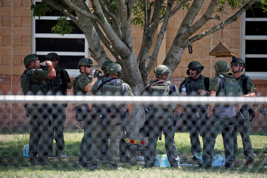 Law enforcement personnel stand outside Robb Elementary School following a shooting.