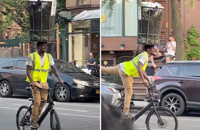 NYC man balances trach can on his head while riding a bike