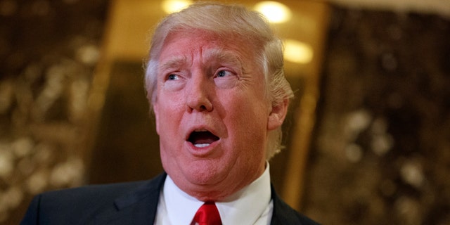 In this Jan. 13, 2017, photo, President-elect Donald Trump speaks with reporters in the lobby of Trump Tower in New York.