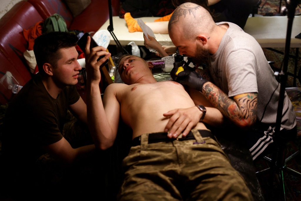 Maksym, 18, a military cadet, gets his first tattoo at a weekly tattoo marathon held to raise funds for the military, amid Russia's invasion, in Podil, Kyiv, Ukraine May 21, 2022.
