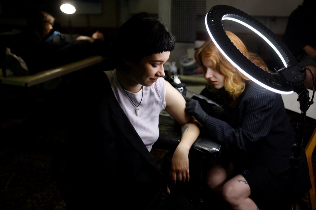 Maria Shustykova, 21, an art student, gets a tattoo of a traditional Motanka (guardian angel) doll tattoo at a weekly tattoo marathon held to raise funds for the military, amid Russia's invasion, in Podil, Kyiv, Ukraine May 21, 2022.