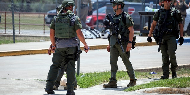 Law enforcement personnel stand outside Robb Elementary School following a shooting Tuesday, May 24, 2022, in Uvalde, Texas. 