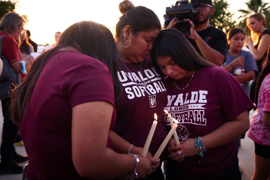 People hold candles at a vigil at Uvalde County Arena after a mass shooting at Robb Elementary School in Uvalde, Texas.