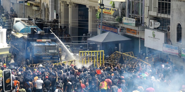 Police use water canon and tear gas to disperse the protesters in Colombo, Sri Lanka, Saturday, July 9, 2022. Sri Lankan protesters demanding that President Gotabaya Rajapaksa resign forced their way into his official residence on Saturday, a local television report said, as thousands of people took to the streets in the capital decrying the island nation's worst economic crisis in recent memory. (AP Photo/Amitha Thennakoon)