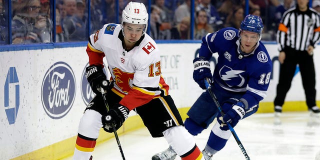 Calgary Flames left wing Johnny Gaudreau (13) carries the puck past Tampa Bay Lightning left wing Ondrej Palat (18) during the third period of an NHL hockey game, Jan. 11, 2018, in Tampa, Fla. Executives around the NHL expect plenty of movement before free agency opens Wednesday, July 13, 2022. Several top players including Gaudreau and Palat could still sign contracts prior to hitting the open market. 