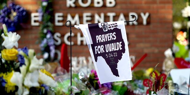 A banner hangs at a memorial outside Robb Elementary School, the site of a May mass shooting that killed 19 students and two teachers.