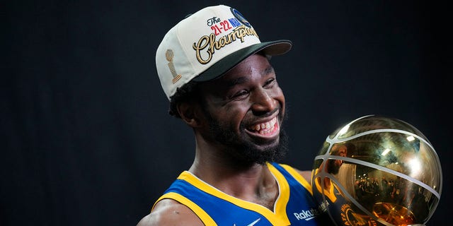 Golden State Warriors' Andrew Wiggins poses for a portrait with the Larry O'Brien Championship Trophy after winning Game Six of the 2022 NBA Finals on June 16, 2022, at TD Garden in Boston, Massachusetts. 
