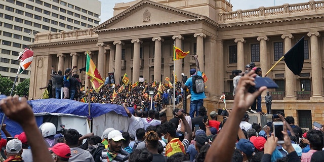 Protesters, many carrying Sri Lankan flags, gather outside the president's office in Colombo, Sri Lanka, Saturday, July 9, 2022.