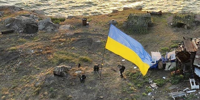 Ukrainian soldiers install the state flag on Snake island, in the Black Sea July 7, 2022. The Ukrainian military returned the flag of Ukraine to island, which had been under the control of Russian troops for some time. 