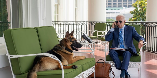 In this image provided by the White House, President Joe Biden speaks on the phone with White House chief of staff Ron Klain from the Truman Balcony, Monday, July 25, 2022, at the White House in Washington. 