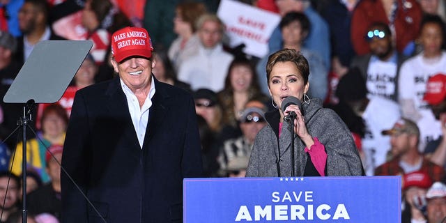 Former US President Donald Trump and Kari Lake, whom Trump is supporting in the Arizona's gubernatorial race, speak during a rally at the Canyon Moon Ranch festival grounds in Florence, Arizona, southeast of Phoenix, on January 15, 2022.