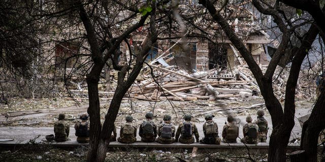 Ukrainian soldiers are sitting at the shelling scene of a destroyed school in Kramatorsk. 