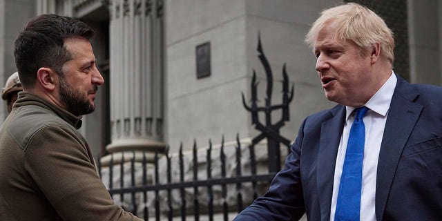 Ukrainian President Volodymyr Zelenskyy and Britain's Prime Minister Boris Johnson, shake hands during their walk in downtown Kyiv, Ukraine, April 9, 2022.