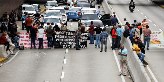 Retired workers of Venezuela’s state-run oil company PDVSA protest outside the company’s headquarters demanding their pension funds, in Caracas, Venezuela, August 3, 2021. 