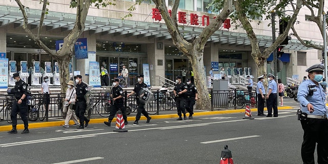 Police officers walk outside the outpatient department of Ruijin Hospital following a stabbing incident, in Shanghai, China July 9, 2022. REUTERS/Brenda Goh