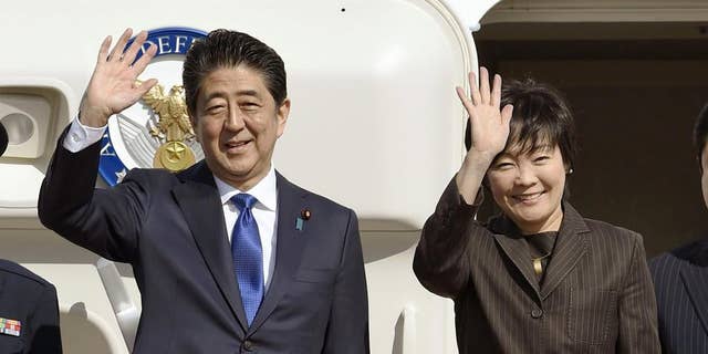 Japanese Prime Minister Shinzo Abe and his wife, Akie, wave prior to their departure to New York, at Haneda airport in Tokyo in November 2016.