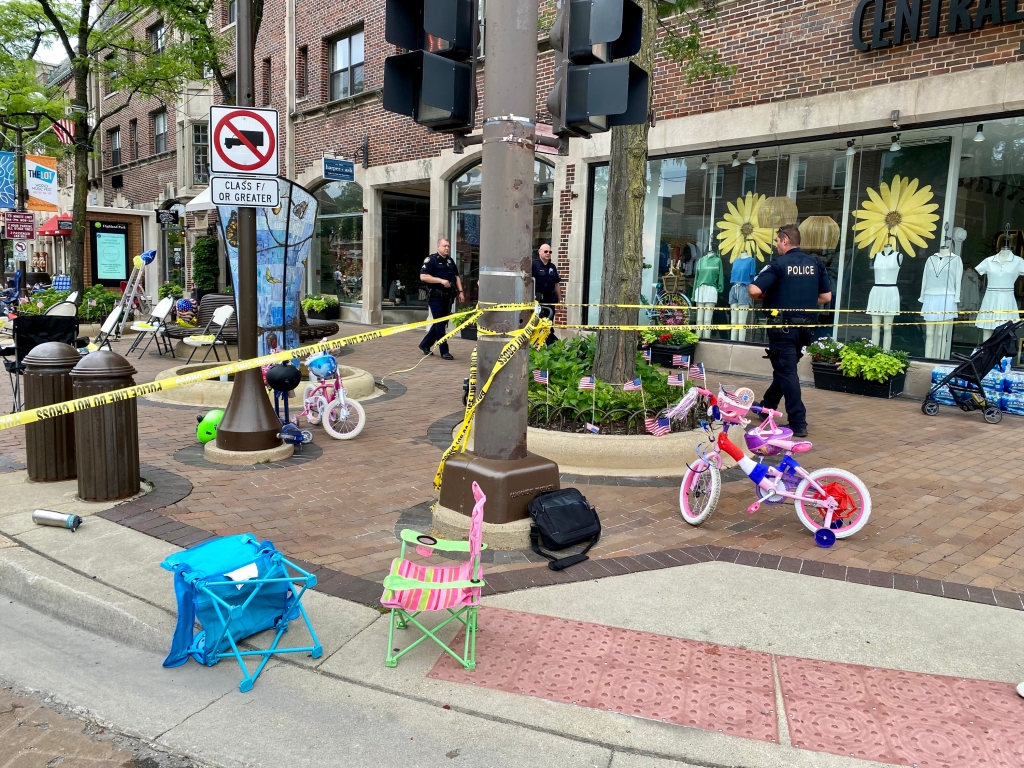 Law enforcement officers walk around a crime scene after a shooting at a Fourth of July parade on July 4, 2022 in Highland Park, Illinois. 