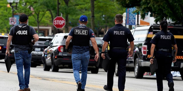 Law enforcement search after a mass shooting at the Highland Park Fourth of July parade in downtown Highland Park, a Chicago suburb on Monday, July 4, 2022. (AP Photo/Nam Y. Huh)