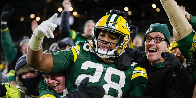 FILE - Green Bay Packers' AJ Dillon celebrates with fans after rushing for a touchdown during the second half of an NFL football game against the Seattle Seahawks, Sunday, Nov. 14, 2021, in Green Bay, Wis.