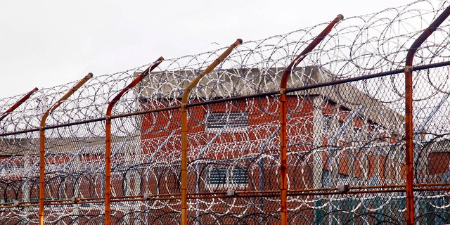 In this March 16, 2011, file photo, a security fence surrounds inmate housing on the Rikers Island correctional facility in New York. 