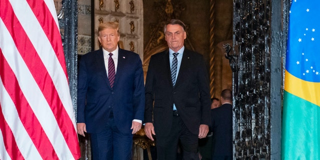 President Donald Trump arrive before a dinner with Brazilian President Jair Bolsonaro at Mar-a-Lago, Saturday, March 7, 2020, in Palm Beach, Fla. (AP Photo/Alex Brandon)