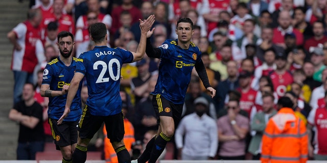 Manchester United's Cristiano Ronaldo, right, celebrates after scoring his side's first goal during an English Premier League soccer match between Arsenal and Manchester United at the Emirates stadium in London, Saturday April 23, 2022. 