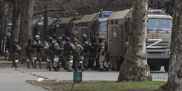 Russian army soldiers stand next to their trucks during a rally against Russian occupation in Svobody (Freedom) Square in Kherson, Ukraine, Monday, March 7, 2022.