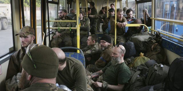 Ukrainian servicemen sit in a bus after they were evacuated from the besieged Mariupol's Azovstal steel plant, near a prison in Olyonivka, in territory under the government of the Donetsk People's Republic, eastern Ukraine, Tuesday, May 17, 2022. More than 260 fighters, some severely wounded, were pulled from a steel plant.