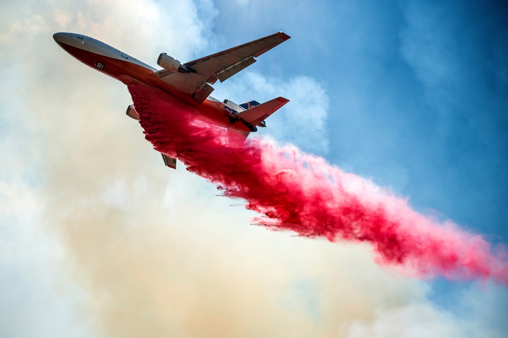 An air tanker drops retardant while battling the Electra Fire in the Pine Acres community of Amador County, Calif.