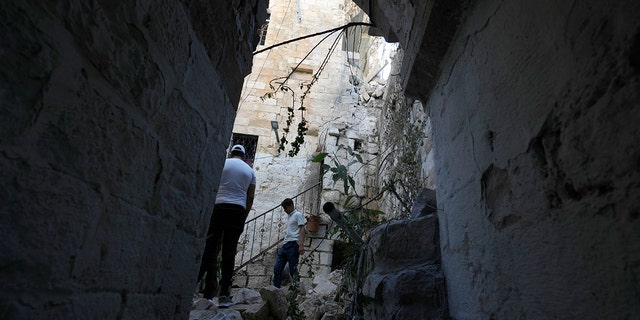 Palestinians inspect the damage to a house after Palestinian gunmen were killed in an early morning Israeli military raid in the Old City of Nablus in the West Bank, Sunday, July 24, 2022. 