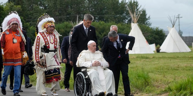 Pope Francis leaves with Indigenous peoples after praying in a cemetery at the former residential school, in Maskwacis, near Edmonton, Canada, Monday, July 25, 2022. Pope Francis begins a "penitential" visit to Canada to beg forgiveness from survivors of the country's residential schools, where Catholic missionaries contributed to the "cultural genocide" of generations of Indigenous children by trying to stamp out their languages, cultures and traditions. Francis set to visit the cemetery at the former residential school in Maskwacis. (AP Photo/Gregorio Borgia)