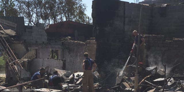 Firefighters work at a damaged residential building following Russian shelling on the outskirts of Odesa, Ukraine, Tuesday, July 26, 2022. 