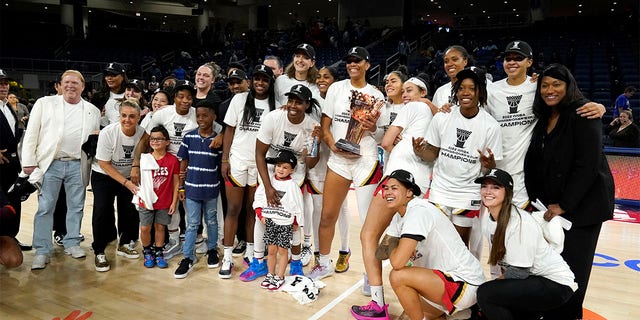 The Las Vegas Aces, with team owner Mark Davis, left, pose for a team photo after defeating the Chicago Sky in the WNBA Commissioner's Cup basketball game Tuesday, July 26, 2022, in Chicago. The Aces won 93-83. 