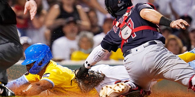 Cleveland Guardians catcher Austin Hedges, right, tags out Boston Red Sox's Xander Bogaerts, who was while trying to score on a fly out by Kevin Plawecki during the third inning during a baseball game at Fenway Park, Tuesday, July 26, 2022, in Boston. 